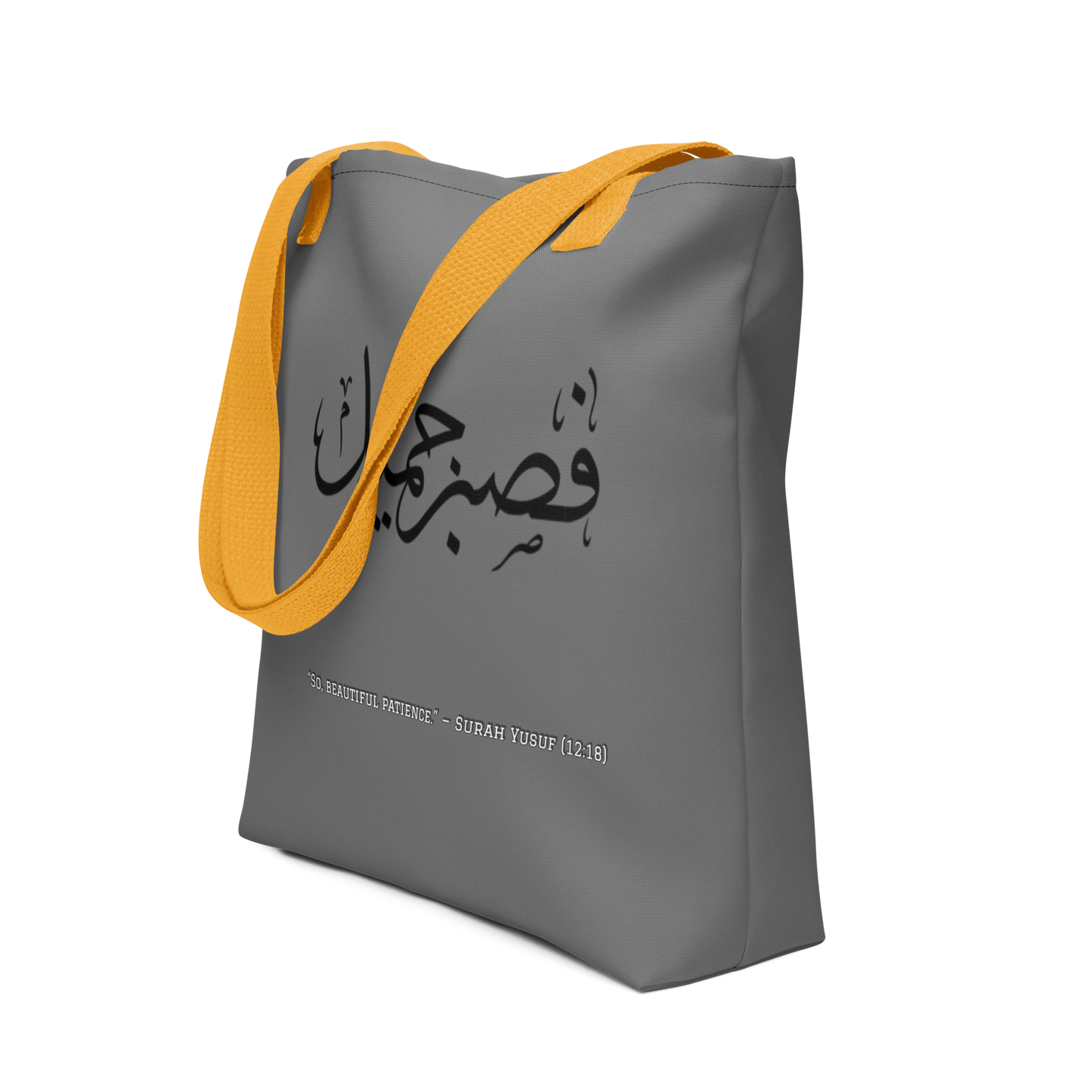 Gray tote bag with yellow strap and Arabic text on a white background