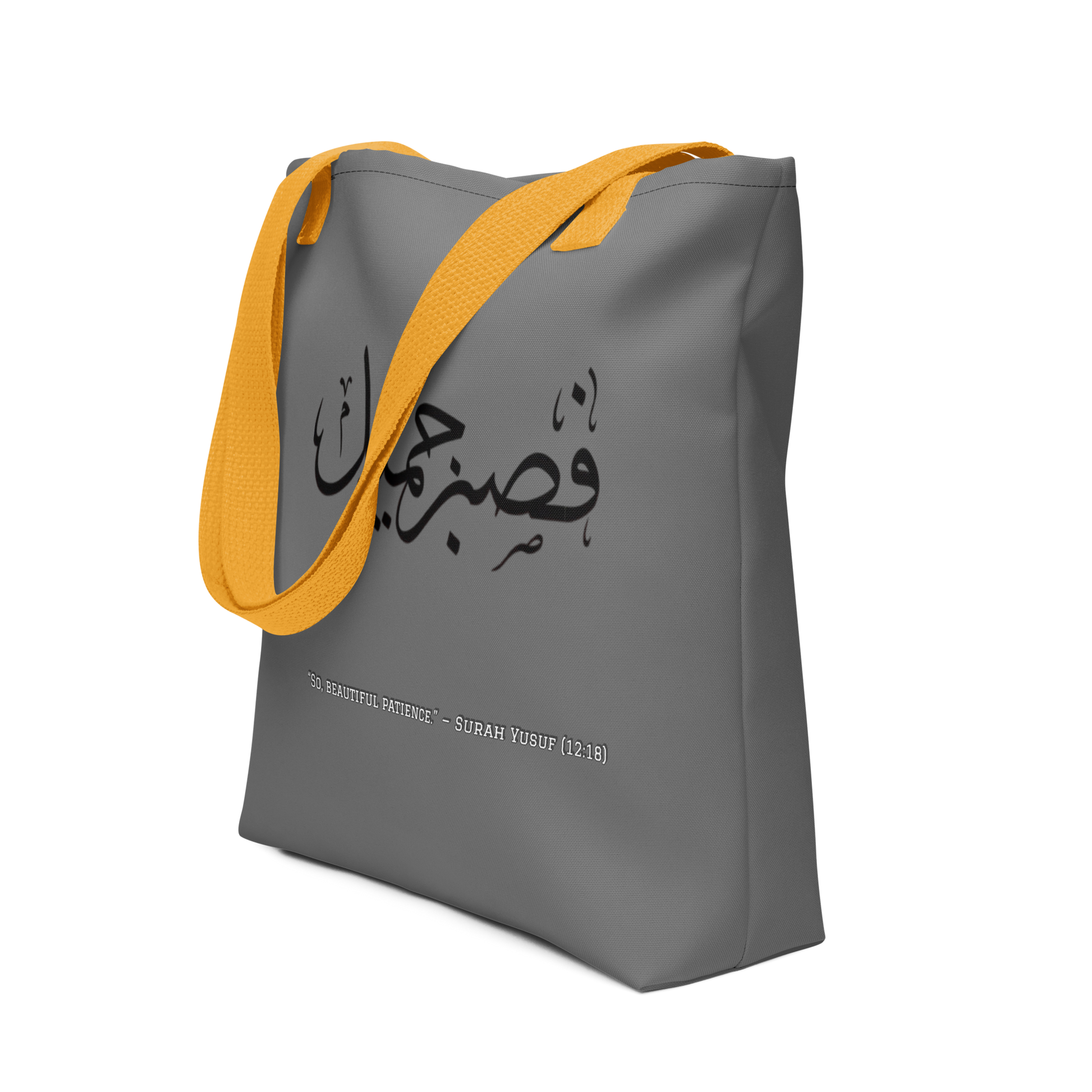 Gray tote bag with yellow strap and Arabic text on a white background